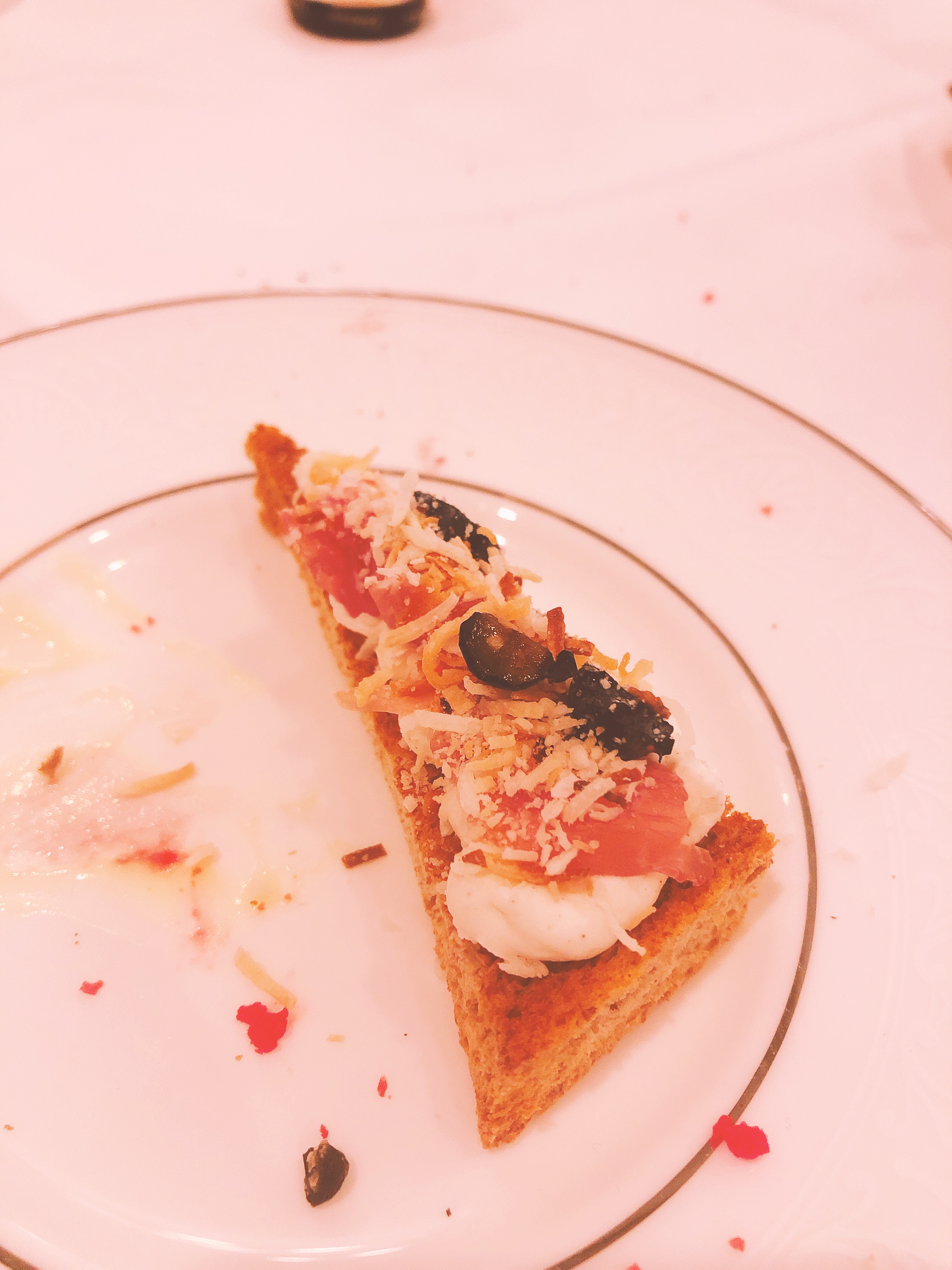 Blueberry, Ricotta, Prosciutto, and Shredded Coconut Sandwich. Bits of all the ingredients listed above on toasted triangle-shaped sandwich.